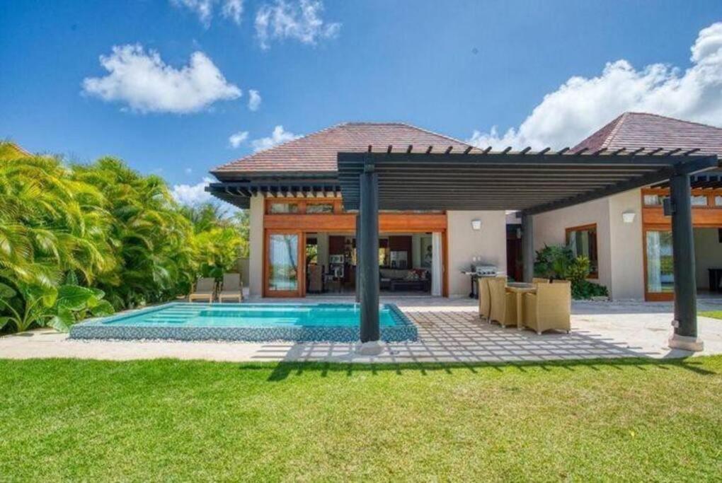 a villa with a swimming pool and a house at Luxury private village Cap Cana in Punta Cana