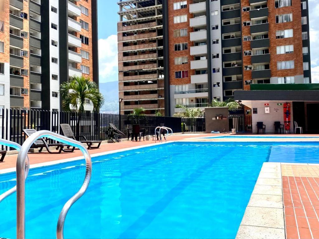 een groot zwembad met stoelen en gebouwen bij Torres de mayorca in Sabaneta