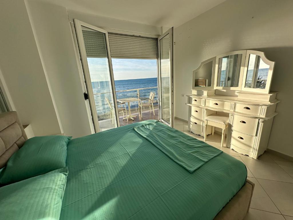 a bedroom with a bed and a view of the ocean at Summer Holiday in Shëngjin