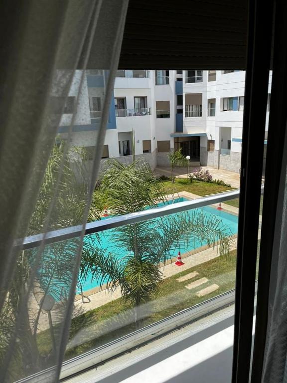 a view of a swimming pool from a window at Harhoura Modern Flat in Temara