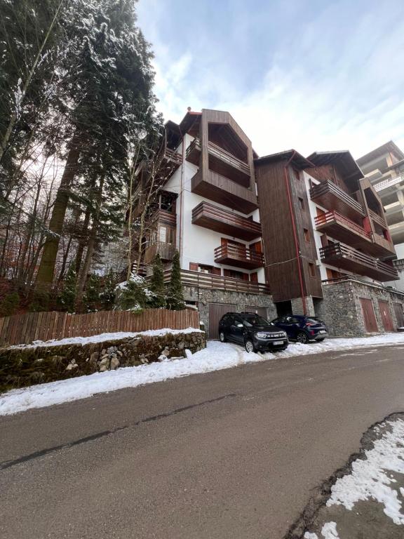 un edificio con un coche aparcado delante en Vista Verde Apartment, en Sinaia