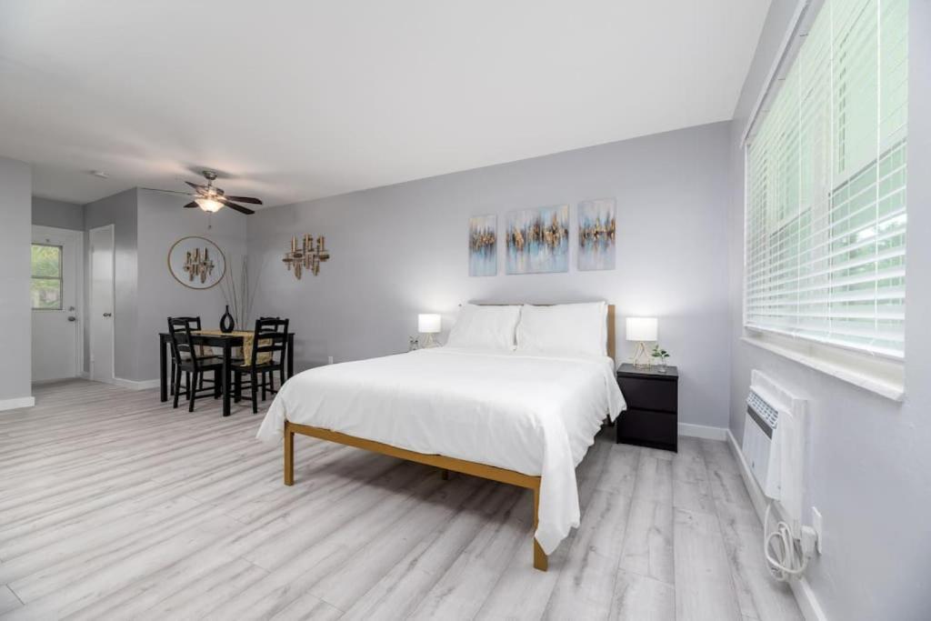 a bedroom with a white bed and a dining room at Just Off Wilton Drive Apt 5 in Fort Lauderdale