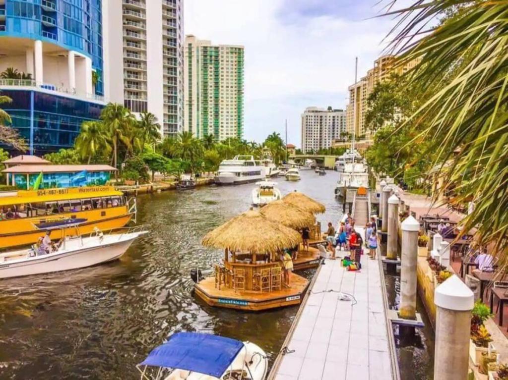 un groupe de bateaux dans une rivière avec des bâtiments dans l'établissement The Residences at Lake Ridge Apt 2, à Fort Lauderdale