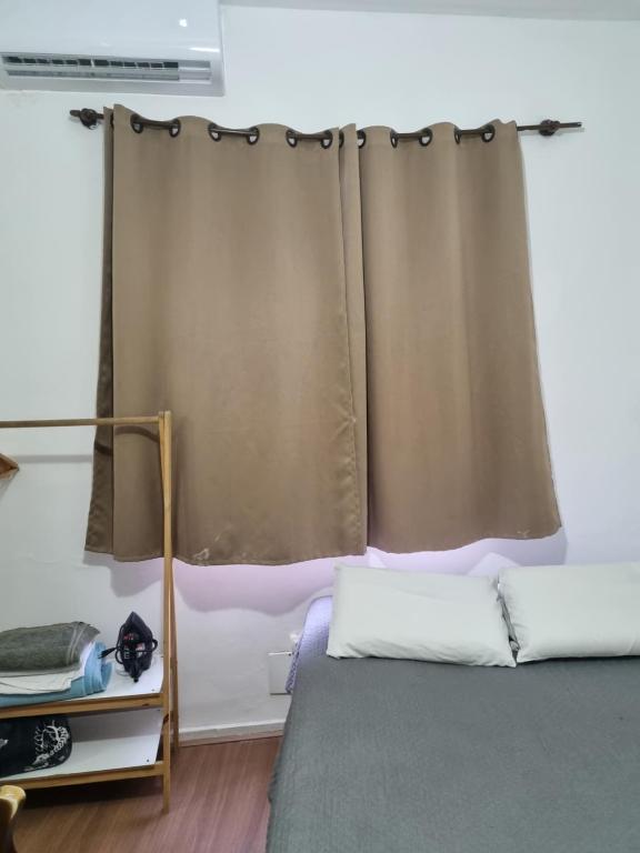 ein Schlafzimmer mit einem Bett und einem Fenster mit einem Vorhang in der Unterkunft Apartamento aconchegante em Copacabana - unid 1016 in Rio de Janeiro