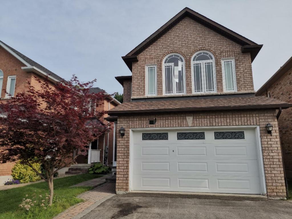 a house with a white garage door at Cosy room in Richmond Hill
