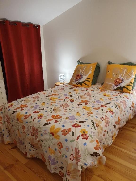 a bedroom with a bed with a floral comforter at Chez Danièle et Jean-Pierre in Saint-Julien