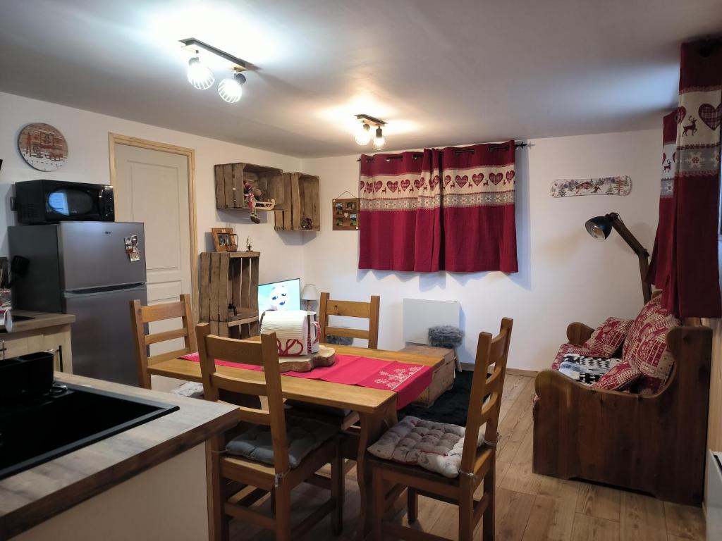 a kitchen with a table and chairs in a room at La sapinette avec jaccuzzi in La Bâthie