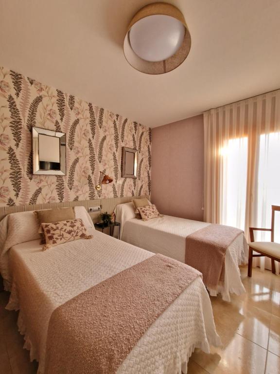 Habitación de hotel con 2 camas y espejo en Apartahotel La Chipranera, en Castejón de Monegros
