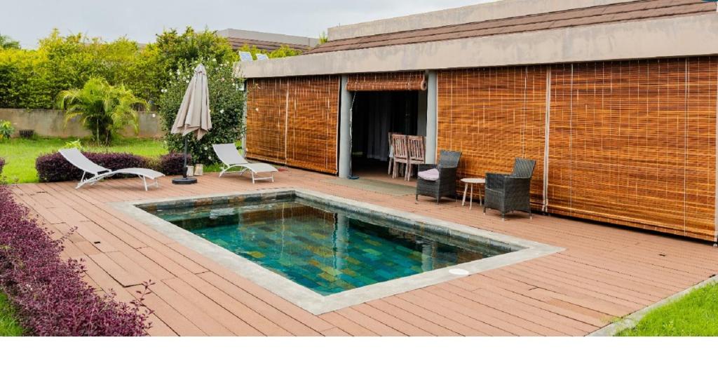 a swimming pool on a wooden deck next to a building at Grand Bay Luxury Villa with Pool & Garden in Grand Baie