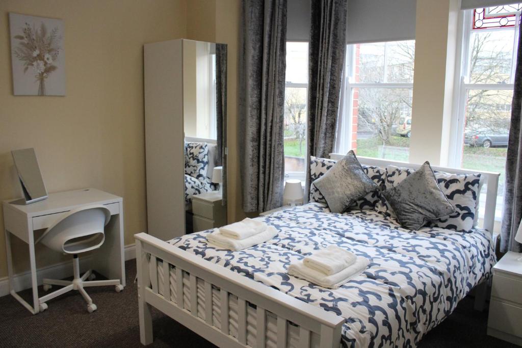 1 dormitorio con cama, escritorio y ventana en Station Rooms en Londonderry County Borough