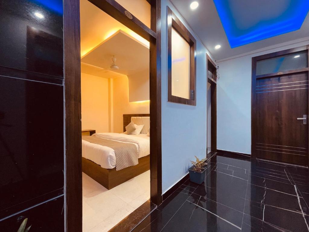 um quarto com uma cama e uma porta que leva a um quarto em The Ganga Divine - A Family Hotel em Haridwar
