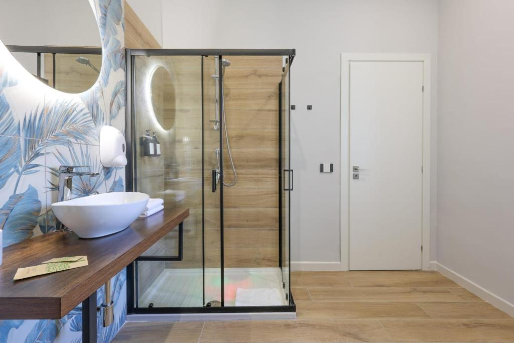 a bathroom with a glass shower with a sink at Cuore Napoli Centro in Naples