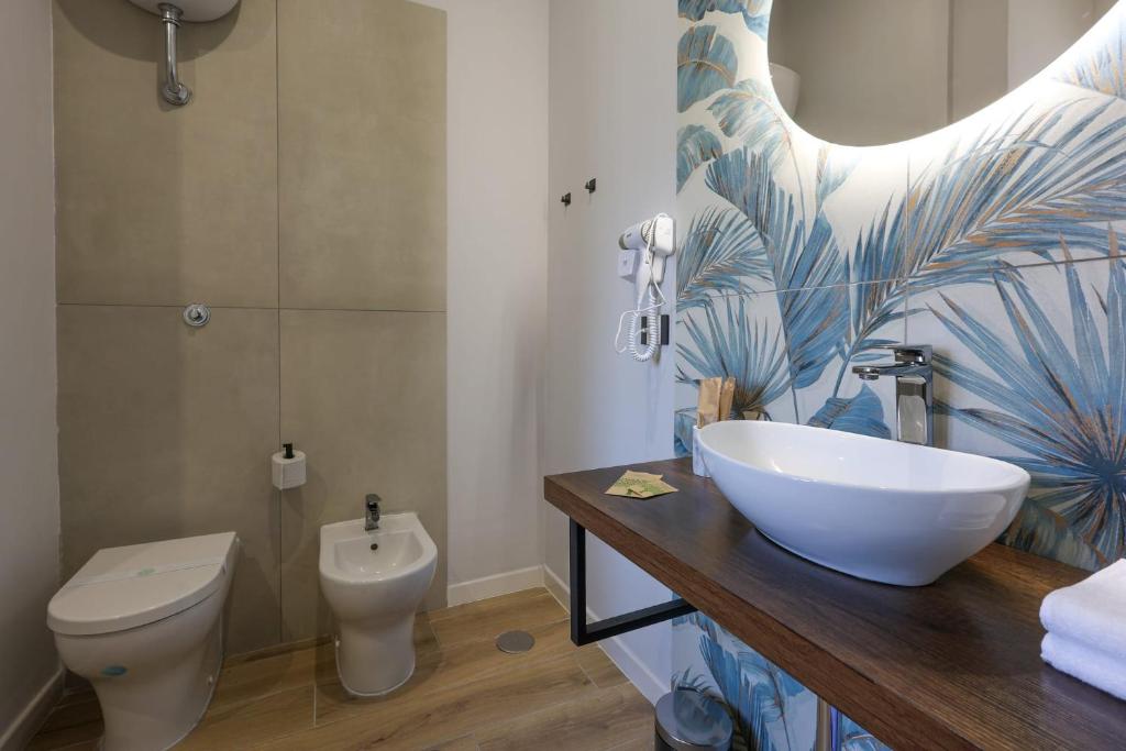 a bathroom with a sink and a toilet at Cuore Napoli Centro in Naples