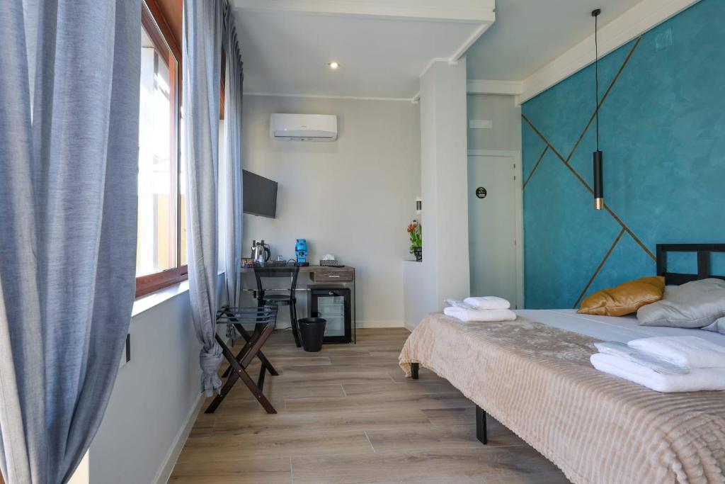 a bedroom with a bed with a blue wall at Cuore Napoli Centro in Naples
