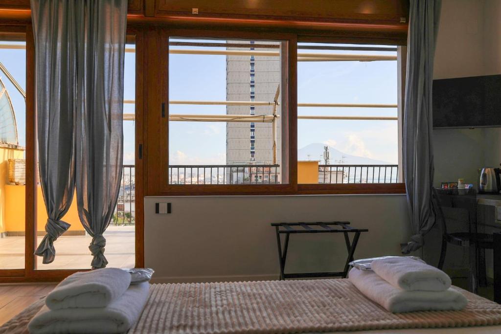a bedroom with a bed and a large window at Cuore Napoli Centro in Naples