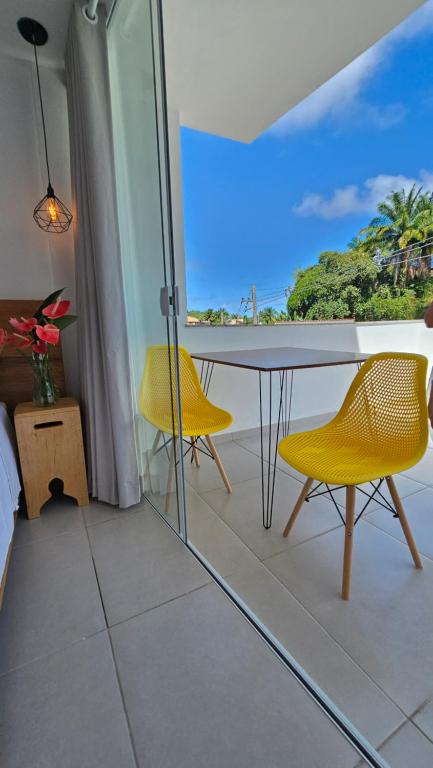 balcone con tavolo e 2 sedie gialle di Estúdio Arruda a Itacaré