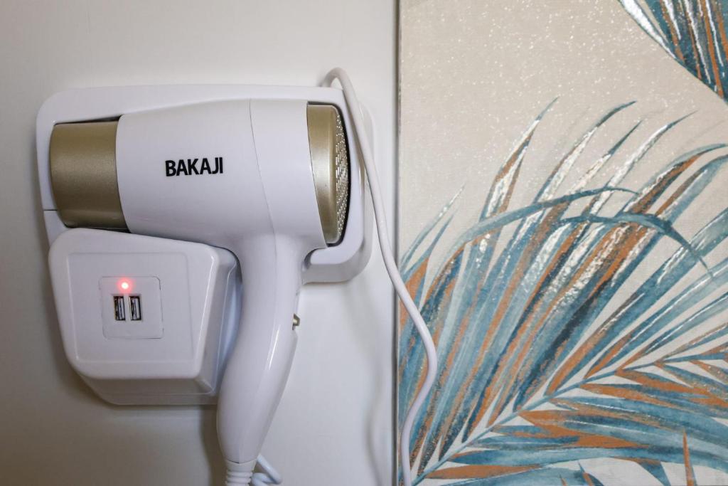 a white hair dryer is plugged into a wall at Cuore Napoli Centro in Naples