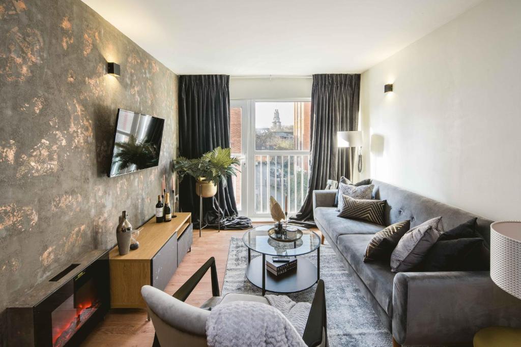 a living room with a couch and a fireplace at Canary Wharf 2-Bed Luxury Haven in London