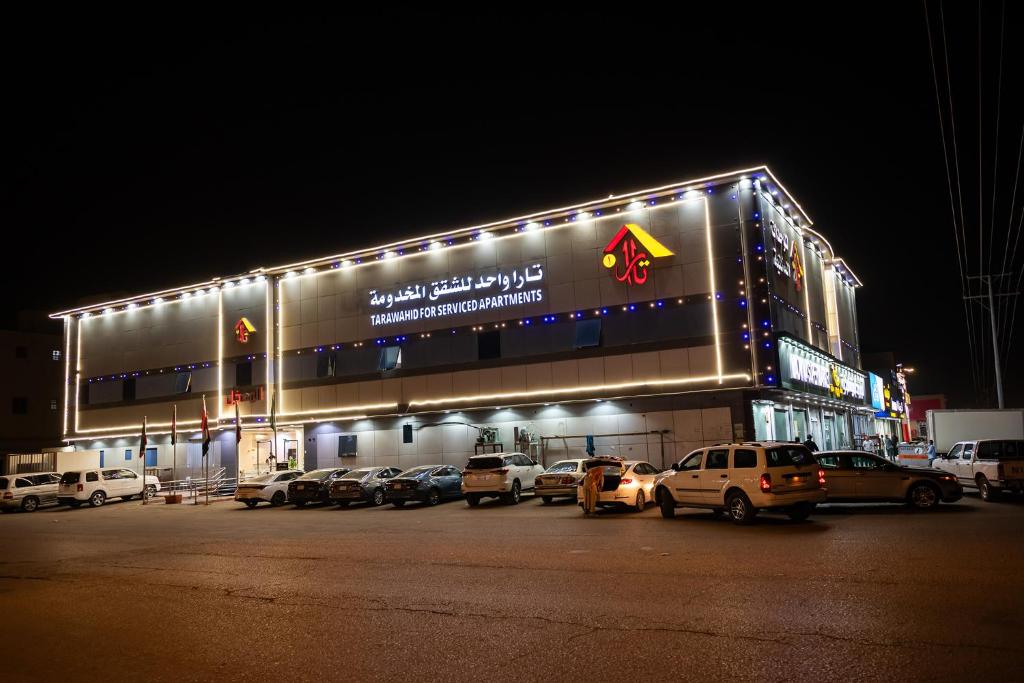 a building with cars parked in a parking lot at night at Tara One Apartment By Alin in Riyadh