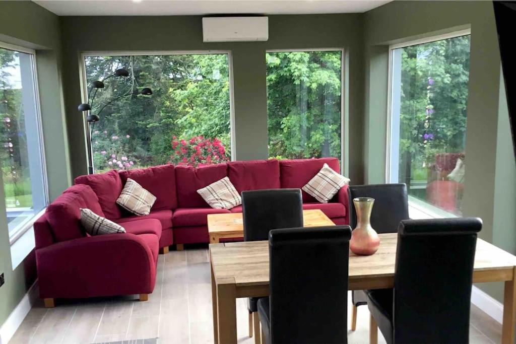 a living room with a red couch and a table at Mary cottage at Tonylion house Kilnaleck in Cavan