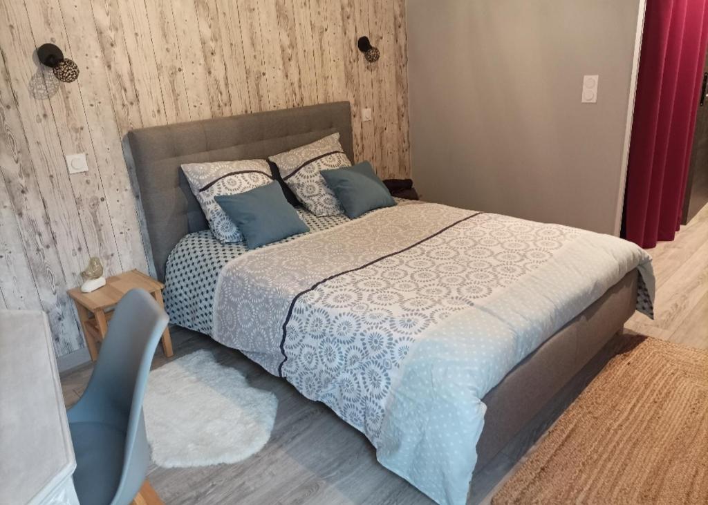 Lumbin的住宿－Cocon au pied de la Chartreuse，一间卧室配有一张带蓝色枕头的床
