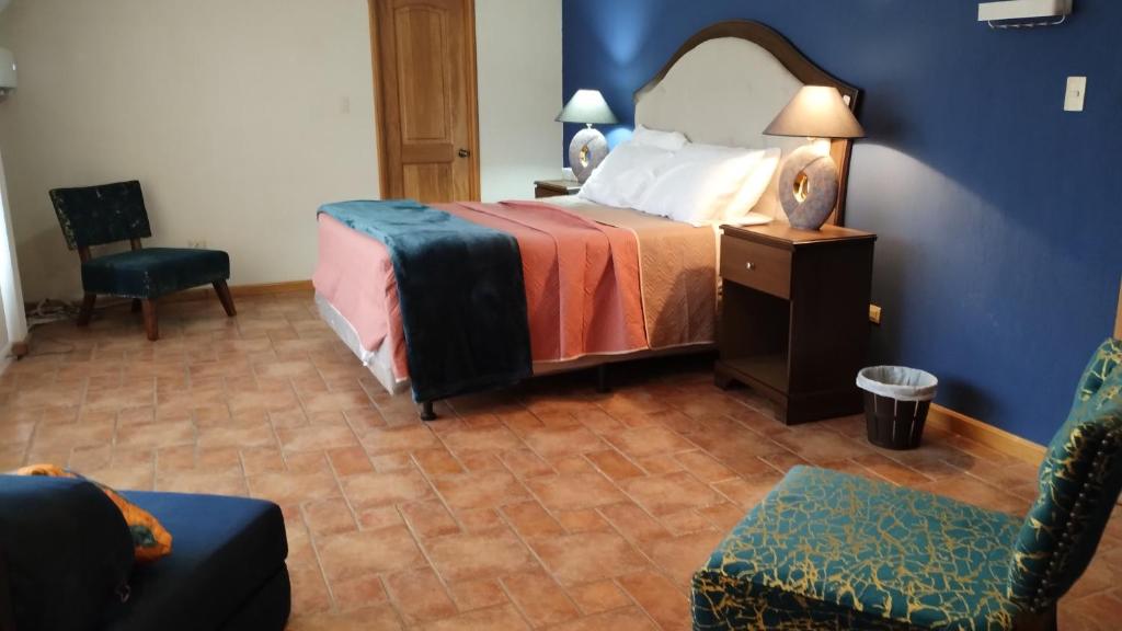 a hotel room with a bed and a chair at Amplia habitación Hacienda Santo Domingo in San Lucas Sacatepéquez