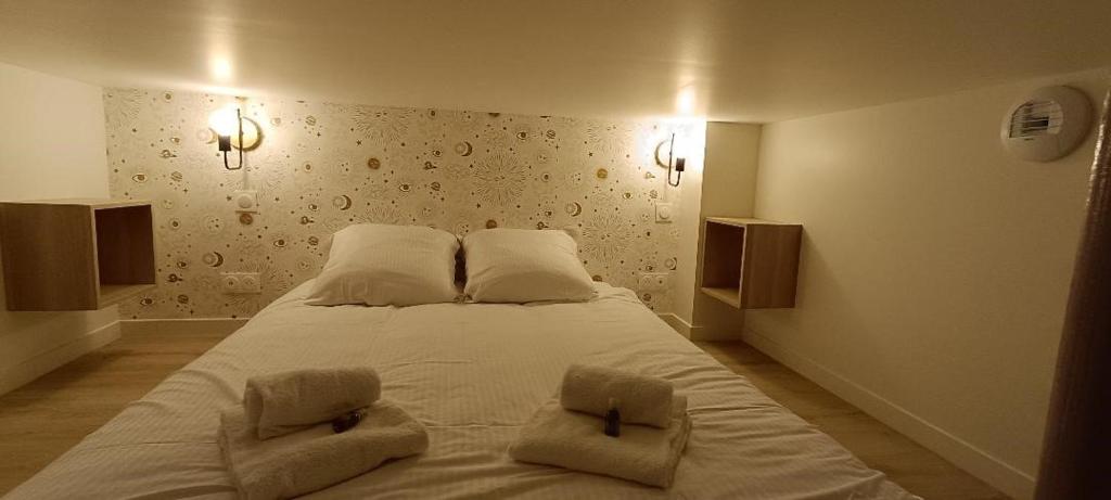 a bedroom with a large white bed with two pillows at Antares - SILS --- 2 chambres séparées en mezzanine in Caen