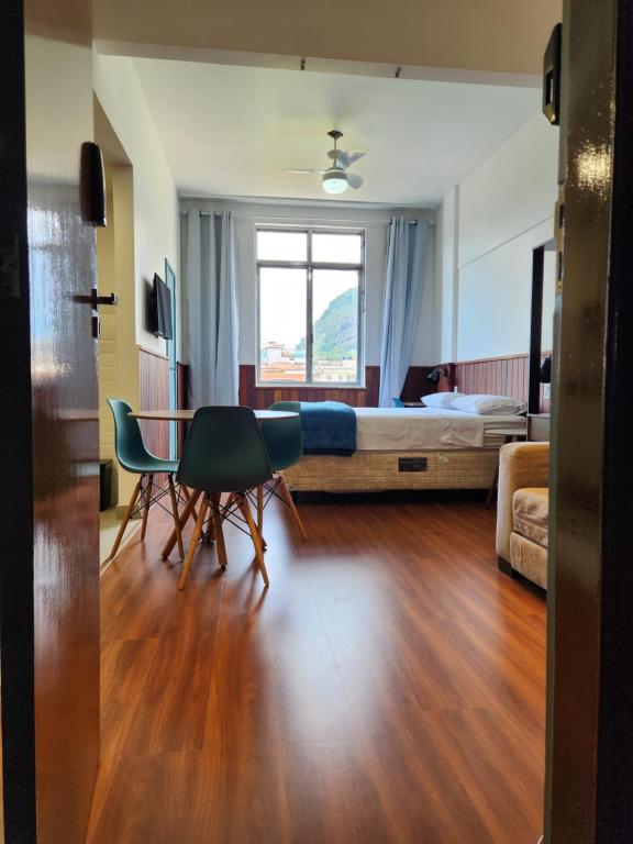 Habitación con cama, mesa y sillas. en Flat 335 - excelente localizacão, estacionamento, en Teresópolis
