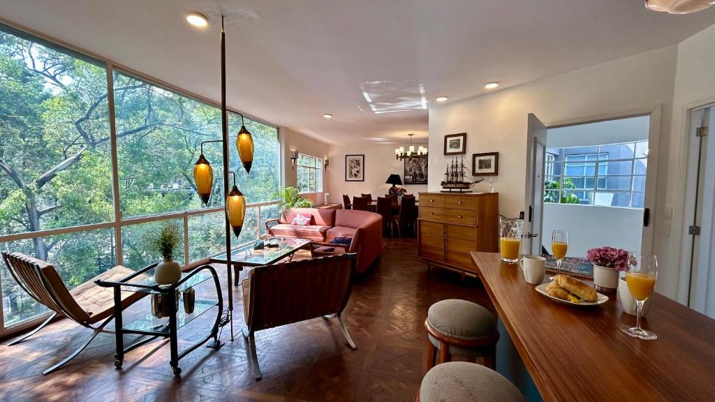 a living room with a table and a dining room at Roma Deco Suites in Mexico City