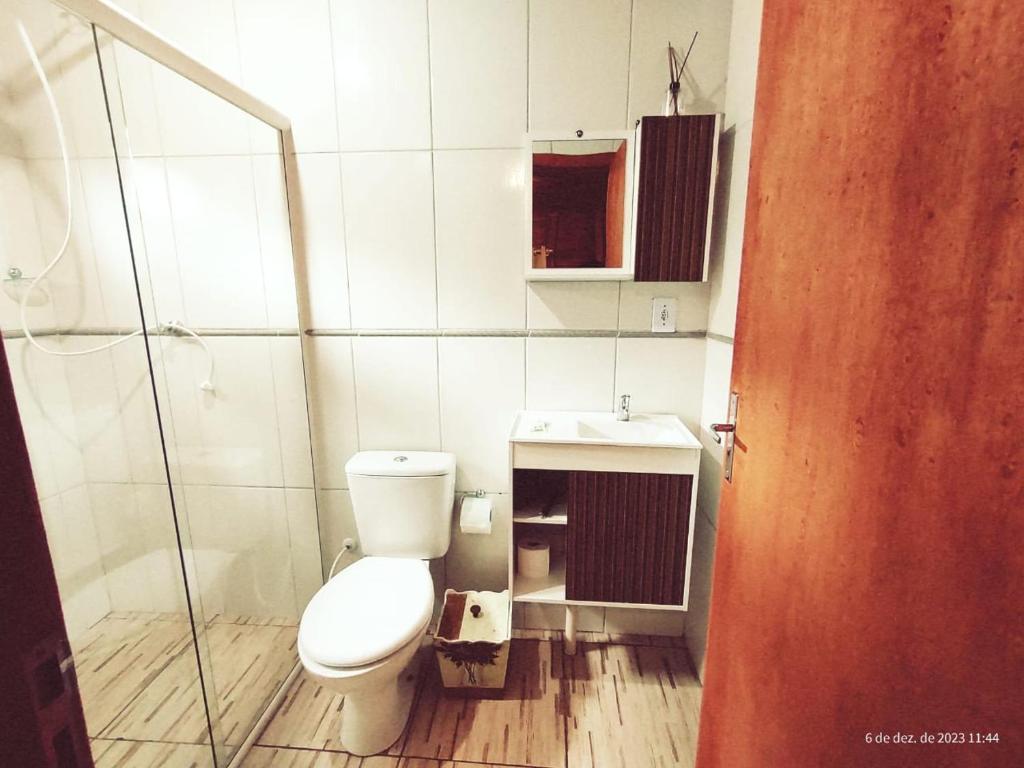 uma casa de banho com um WC e uma cabina de duche em vidro. em Pousada Floresta Das Estrelas em Urubici