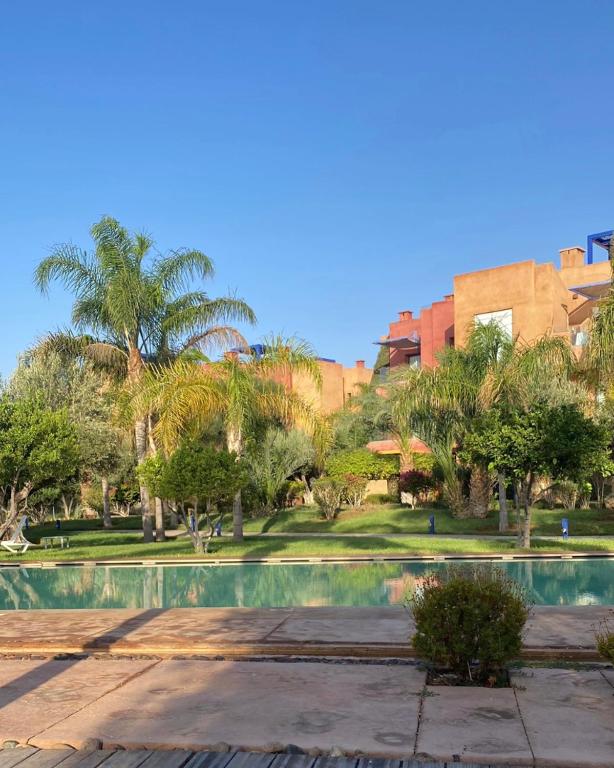 uma piscina num parque com palmeiras em Vizir-Private Family em Marrakech