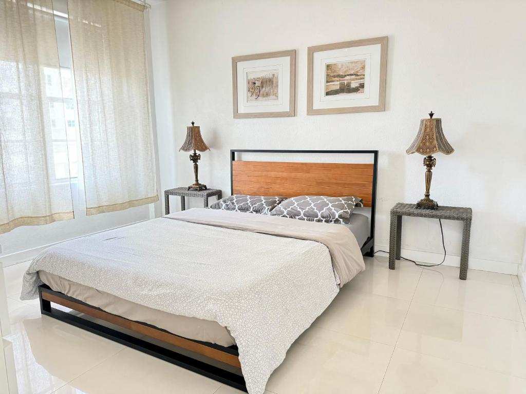 a bedroom with a large bed and two tables at 2 BEDROOM ON THE BEACH ! in Miami Beach