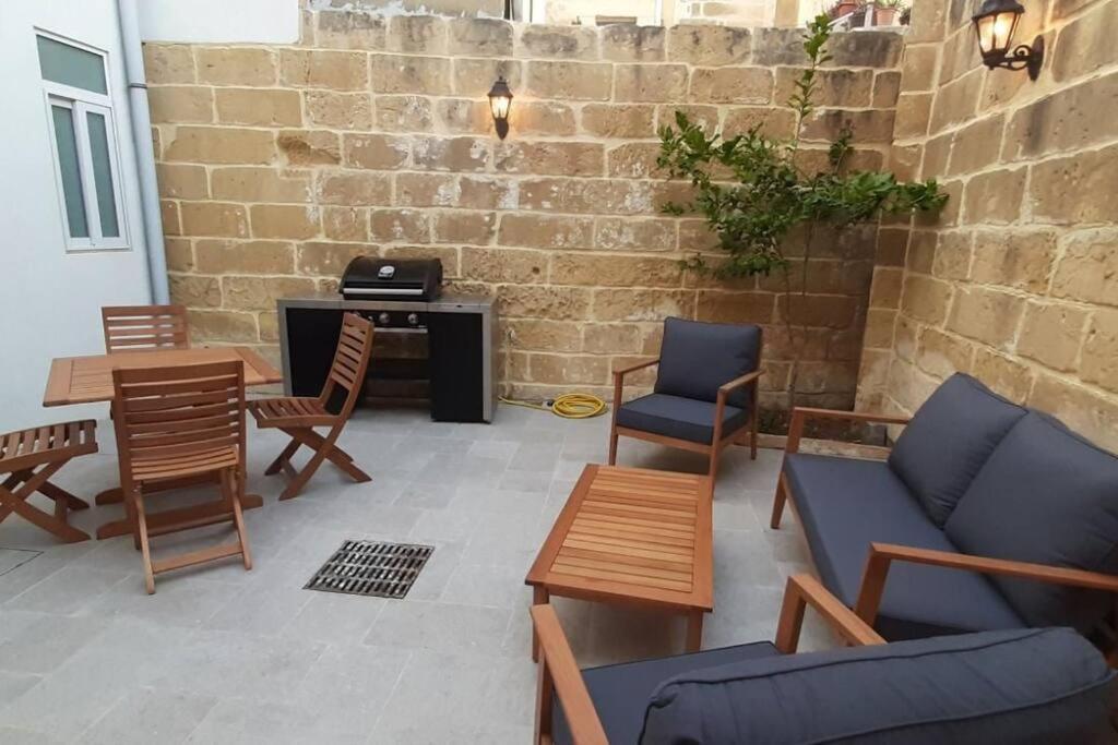 a patio with a couch and chairs and a table at Dahlia apartment - Paola Modern Townhouse in Paola