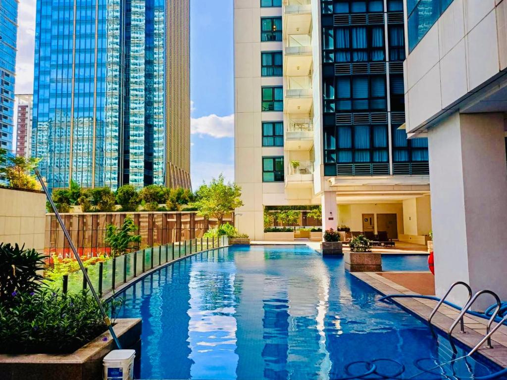 - une piscine au milieu d'un immeuble avec de grands bâtiments dans l'établissement Executive Queen 1BR Luxury Suite 10 - Pool, Wi-Fi, à Manille