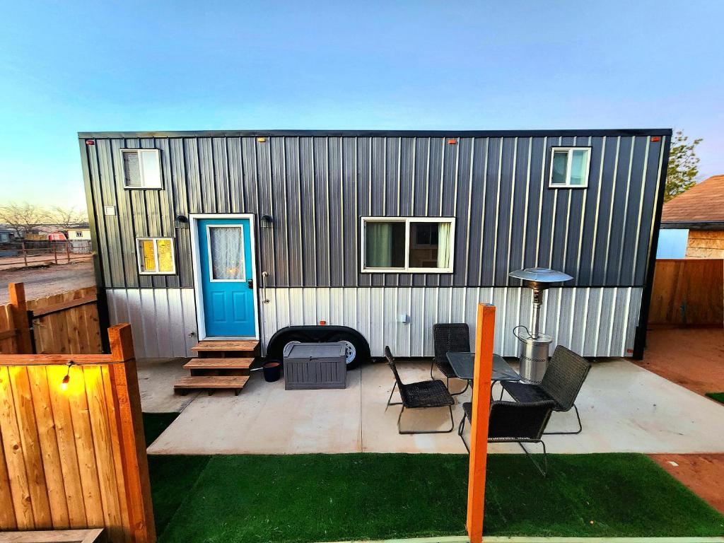 ein kleines Haus auf einer Terrasse mit einem Tisch und Stühlen in der Unterkunft Tiny Home Hot Tub in Colorado City