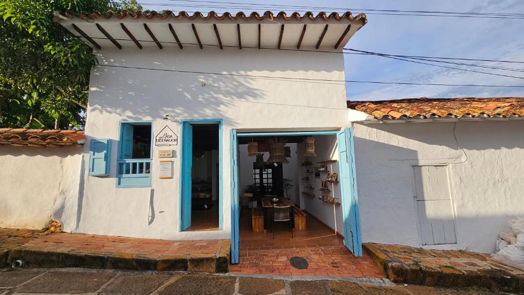 un edificio blanco con puertas azules y porche en La Casa del Diseñador en Barichara