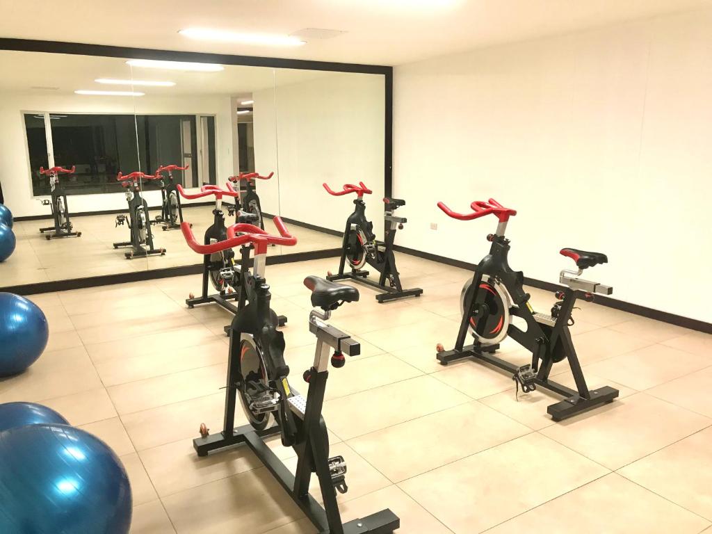 un gimnasio con una fila de cintas de correr y bicicletas estáticas en Gran departamento completamente amoblado en Quito