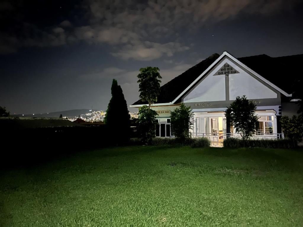 a white house with a cross on top of a yard at Charming 4-Bed House in Kigali in Kigali