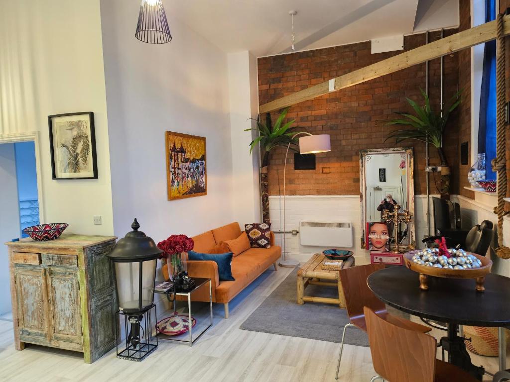 a living room with a couch and a table at Characteristic loft style apartment in Birmingham