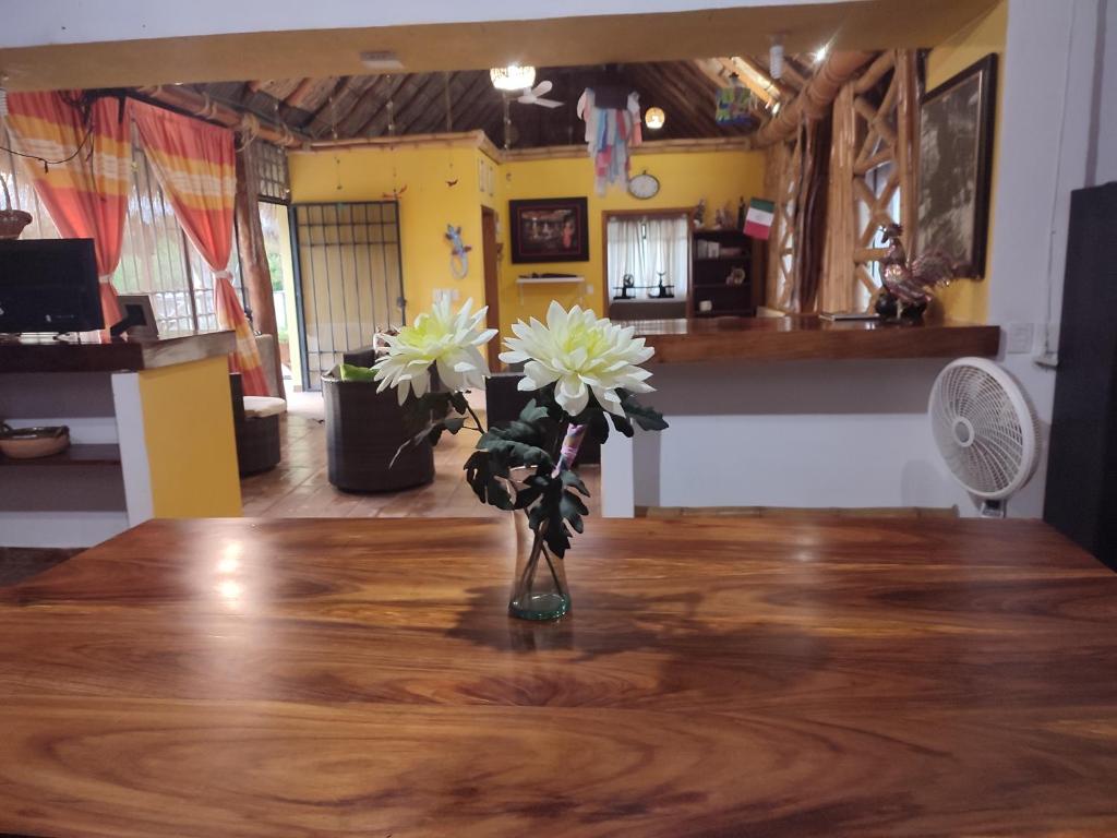 un jarrón con flores blancas sobre una mesa de madera en Casa Matias Romero, en Tangolunda