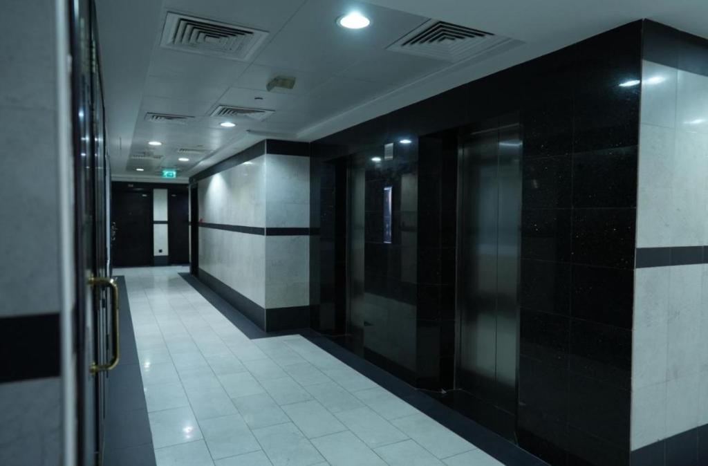 a hallway with black and white walls and a elevator at RksHome Couple or Solo Room Burjuman Metro Exit 4 in Dubai