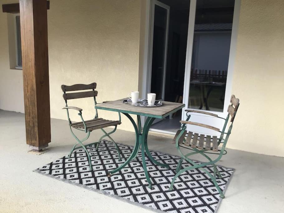 uma mesa e duas cadeiras sentadas num pátio em Guest house « Cantegrit » em Ychoux