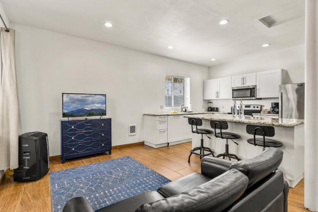 ein Wohnzimmer mit einem Sofa und einer Küche in der Unterkunft Greenlaw Studio in the Pines! in Flagstaff