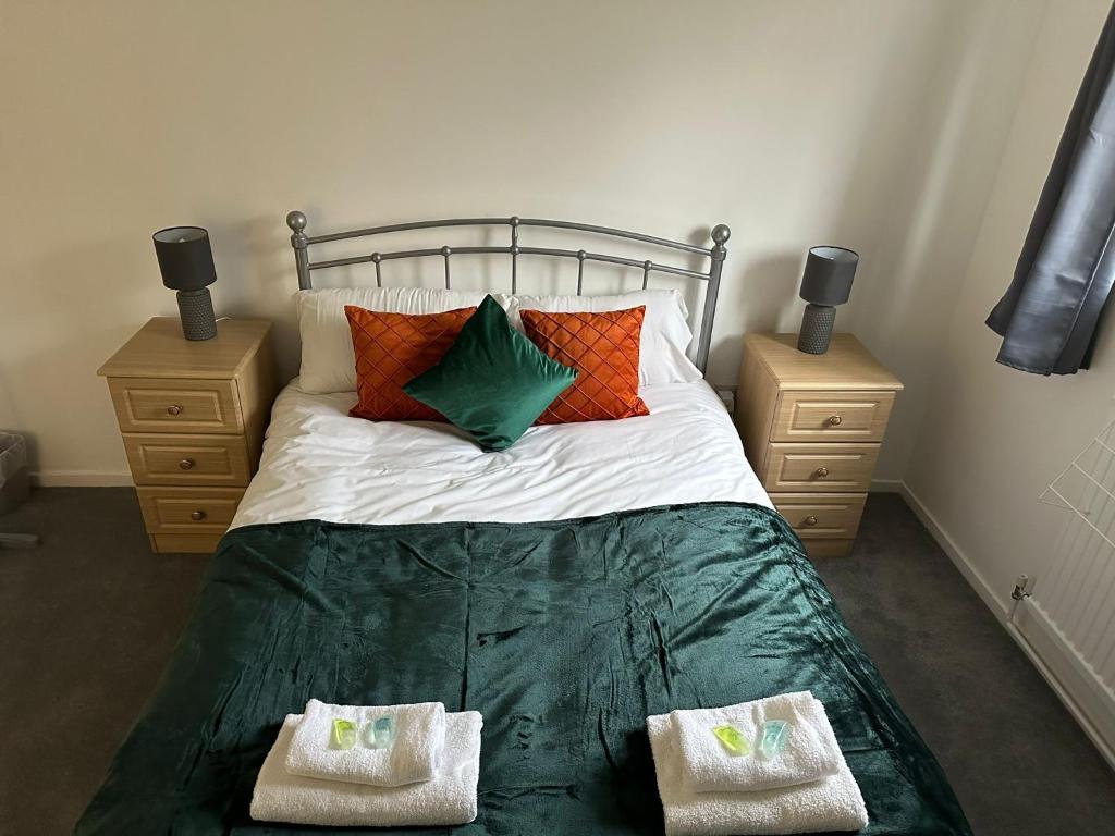 ein Schlafzimmer mit einem Bett mit Kissen und zwei Nachttischen in der Unterkunft Watergall Lodge in Peterborough