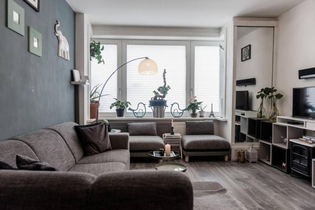a living room with a couch and a large window at Nice 2 double Bed in sunny House in Amsterdam west in Amsterdam