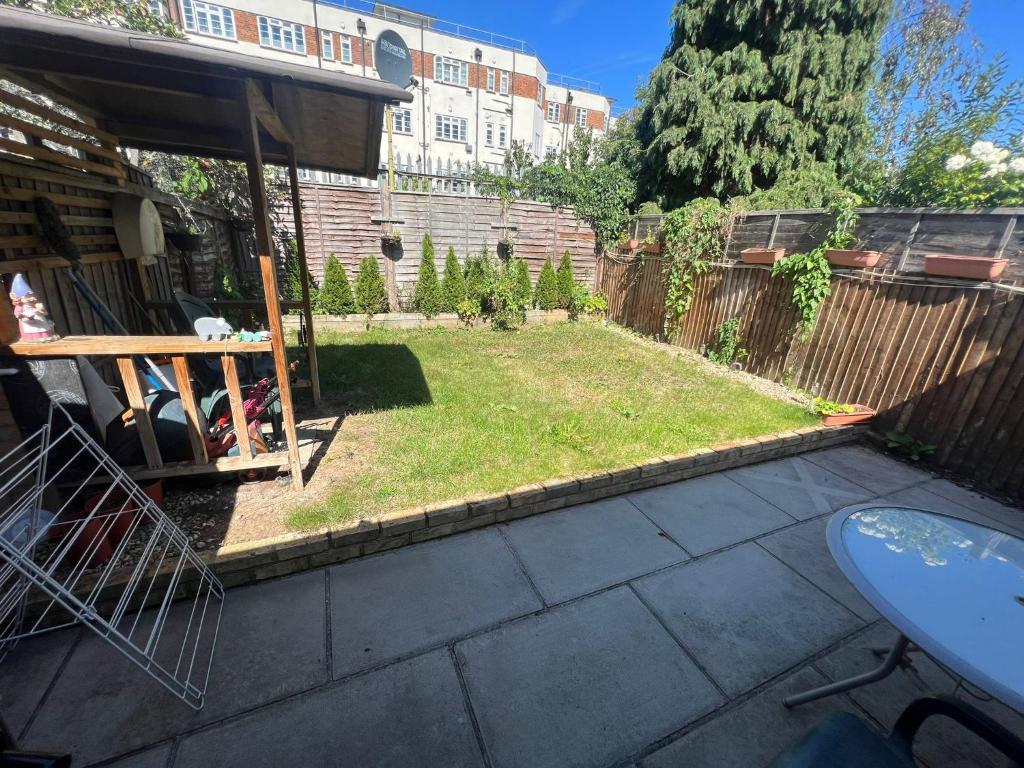 a small garden in a backyard with a fence at N8, Modern 2 bedroom Apartment in London
