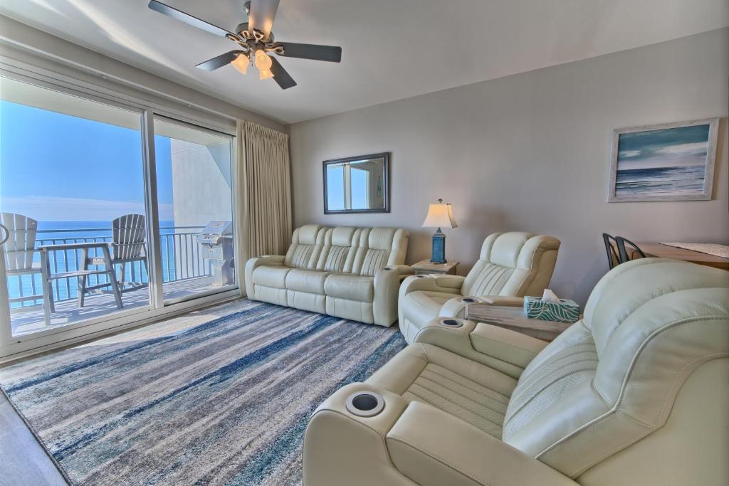 a living room with a couch and chairs and a balcony at OCEAN FRONT CONDO w INCREDIBLE VIEWS in Panama City Beach