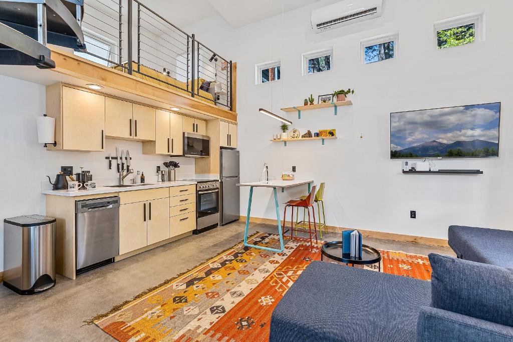 a living room with a blue couch and a kitchen at Enchanting & Newly Built NoHo 1 BDR Loft with AC! in Flagstaff