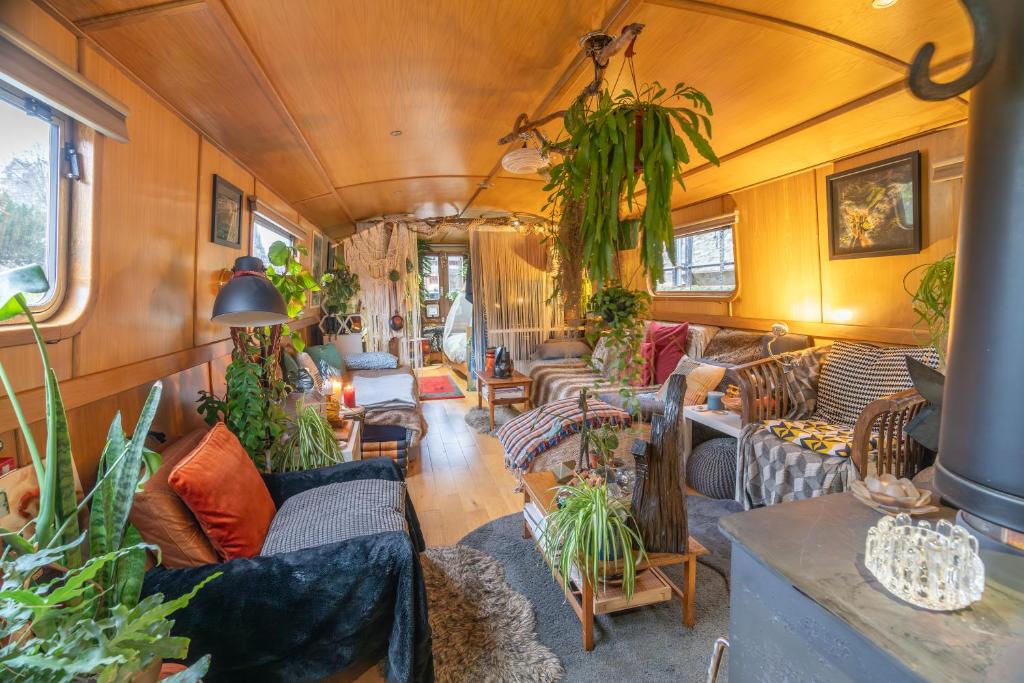 a living room with couches and plants at Floating Cat Palace in the Heart of Bath in Bath