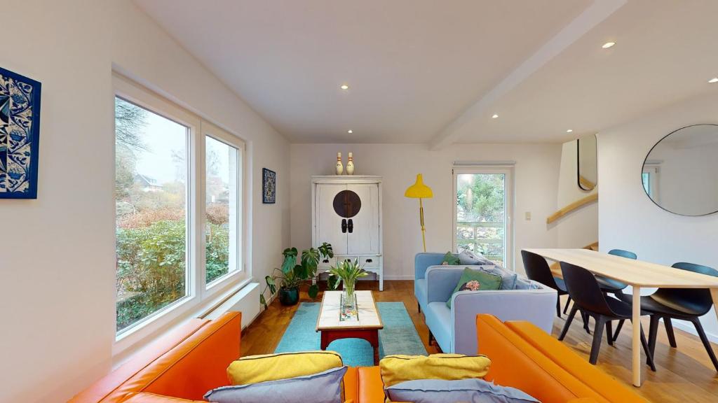 Sint-Genesius-RodeにあるThe Tile House - 2 bedroom property just south of Brusselsのリビングルーム(オレンジ色のソファ、テーブル付)